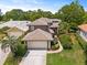 Attractive two-story home with a well-manicured lawn, tile roof, and an attached two-car garage at 14037 Fairway Willow Ln, Winter Garden, FL 34787