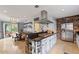 Modern kitchen with stainless steel appliances, stone accents, large island with cooktop and dining area overlooking backyard at 14037 Fairway Willow Ln, Winter Garden, FL 34787
