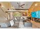 Comfortable living room with a stone fireplace, ceiling fan, neutral paint colors, and staircase at 14037 Fairway Willow Ln, Winter Garden, FL 34787