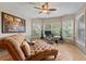 Comfortable home office space featuring a chaise lounge, desk, and windows overlooking the landscaped yard at 14037 Fairway Willow Ln, Winter Garden, FL 34787