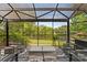 Screened in lanai with comfortable seating, a firepit and views of the large yard and lake at 14037 Fairway Willow Ln, Winter Garden, FL 34787