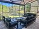 Screened patio with an outdoor seating area and fireplace overlooking a tranquil lake view at 14037 Fairway Willow Ln, Winter Garden, FL 34787