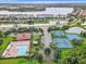 Aerial view of a community with a pool, tennis courts, playground, and scenic lake at 14137 Queenside St, Orlando, FL 32824