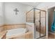 Bathroom showcasing a separate shower with glass doors and soaking tub with tile surround at 14137 Queenside St, Orlando, FL 32824