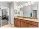 Bathroom featuring double sinks with granite counters and wood cabinets, offering plenty of storage space at 14137 Queenside St, Orlando, FL 32824
