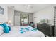 Bedroom featuring a TV and dark dresser, ceiling fan, bed with floral pattern, and a decorative chair at 14137 Queenside St, Orlando, FL 32824