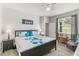 Comfortable bedroom with a ceiling fan, a window, and a bed with decorative pillows and a flower design at 14137 Queenside St, Orlando, FL 32824