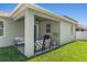 Relaxing covered patio with ceiling fan, grill, and seating overlooking the backyard at 14137 Queenside St, Orlando, FL 32824