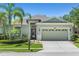 Charming single-story home with lush landscaping, mature palm trees, and a well-manicured lawn at 14137 Queenside St, Orlando, FL 32824