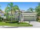 Charming single-story home with lush landscaping, mature palm trees, and a well-manicured lawn at 14137 Queenside St, Orlando, FL 32824
