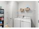 Laundry area with washer, dryer, and shelving for storage at 14137 Queenside St, Orlando, FL 32824