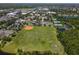 Aerial view of a green baseball field, tennis and basketball courts and a playground near a pond within a residential community at 14262 Tanja King Blvd, Orlando, FL 32828