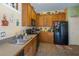 Functional kitchen with wood cabinets, black appliances, and tiled floor, providing ample storage at 14262 Tanja King Blvd, Orlando, FL 32828
