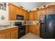 Well-appointed kitchen featuring wood cabinetry and black appliances for a functional cooking space at 14262 Tanja King Blvd, Orlando, FL 32828
