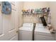 Functional laundry room features a washer, dryer, and storage shelving for convenience at 14262 Tanja King Blvd, Orlando, FL 32828
