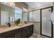 Modern bathroom with double sinks, marble countertops, and a glass-enclosed shower at 15201 Summer Harvest St, Winter Garden, FL 34787