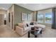 Stylish bonus room with a comfortable sectional sofa, modern decor, and ample natural light from large windows at 15201 Summer Harvest St, Winter Garden, FL 34787