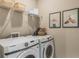 Functional laundry room featuring a washer and dryer, ample storage shelves, and decorative artwork at 15201 Summer Harvest St, Winter Garden, FL 34787