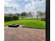 View of the lush backyard with grass, a brick patio, and a water feature at 16124 Azure Key St, Winter Garden, FL 34787