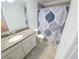 Cozy bathroom featuring a granite countertop vanity and decorative shower curtain at 16124 Azure Key St, Winter Garden, FL 34787
