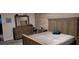 Comfortable bedroom with wood-paneled walls, a dresser, and a king-size bed at 16124 Azure Key St, Winter Garden, FL 34787