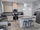 Modern kitchen featuring an island with seating, stainless appliances, and gray cabinets at 16124 Azure Key St, Winter Garden, FL 34787