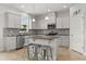 Modern kitchen with stainless steel appliances, center island with seating, and mosaic backsplash at 16124 Azure Key St, Winter Garden, FL 34787