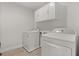 A laundry room features a washing machine and a dryer, complemented by overhead cabinets at 16124 Azure Key St, Winter Garden, FL 34787