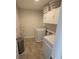 Efficient laundry room with updated machines and overhead storage cabinets at 16124 Azure Key St, Winter Garden, FL 34787