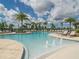 A relaxing community pool lined with lounge chairs under a sunny, cloudy sky at 16124 Azure Key St, Winter Garden, FL 34787