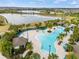 Community pool with abundant seating, palm trees and a view of the lake and surrounding residences at 16124 Azure Key St, Winter Garden, FL 34787