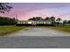 Property with well-kept greenery, red shutters, and convenient RV parking under a beautiful sunset sky at 18906 Merrich Rd, Orlando, FL 32820