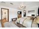 Comfortable main bedroom featuring ceiling fan, television, and an ensuite bathroom with a tub at 18906 Merrich Rd, Orlando, FL 32820