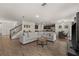 Open-concept living room with wood-look flooring and ample seating and a view of the kitchen at 2294 Canyon Breeze Ave Ave, Kissimmee, FL 34746