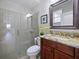 Bathroom featuring a glass enclosed shower, wood cabinet with granite countertop, and decorative mirror at 2365 Sterling Creek Pkwy, Oviedo, FL 32766