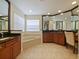 Bright bathroom features a soaking tub, dark granite counters, and warm cabinetry at 2365 Sterling Creek Pkwy, Oviedo, FL 32766