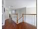 Upstairs hallway boasts wood floors, a staircase, and views into other rooms at 2365 Sterling Creek Pkwy, Oviedo, FL 32766