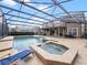 Backyard view of large screened-in pool with spa and outdoor dining area at 2365 Sterling Creek Pkwy, Oviedo, FL 32766