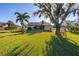 Spacious backyard featuring mature trees, lush green grass, and a cozy swing, perfect for relaxing at 241 Lake Thomas Dr, Winter Haven, FL 33880