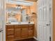 The bathroom features wood cabinetry, mirror, and a door to the bedroom at 241 Lake Thomas Dr, Winter Haven, FL 33880