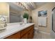 Bright bathroom with a large mirror, vanity, and shower with glass door at 241 Lake Thomas Dr, Winter Haven, FL 33880