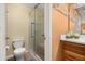 Bathroom offering a toilet, glass enclosed shower, and a wooden vanity cabinet at 241 Lake Thomas Dr, Winter Haven, FL 33880