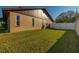 Side view of the house, revealing well-kept lawn, neutral paint and a clean white fence at 241 Lake Thomas Dr, Winter Haven, FL 33880