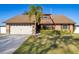 Charming single-story home with lush lawn, mature landscaping, and a two car garage at 241 Lake Thomas Dr, Winter Haven, FL 33880