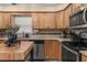 Bright kitchen features wood cabinets, stainless steel appliances, and granite countertops at 241 Lake Thomas Dr, Winter Haven, FL 33880