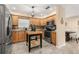 Well-lit kitchen offers wooden cabinetry, a stainless steel refrigerator and breakfast table with chairs at 241 Lake Thomas Dr, Winter Haven, FL 33880