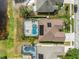 Aerial view of a home with a screened-in pool, solar panels, and a well-manicured lawn at 2787 Cypress Head Trl, Oviedo, FL 32765