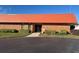 Community clubhouse featuring brick exterior, red roof, manicured landscaping, and ample parking at 3009 Manatee Rd, Tavares, FL 32778