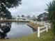 Scenic pond view with white picket fence surrounding the homes and lush greenery at 3009 Manatee Rd, Tavares, FL 32778