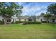 Well-maintained backyard featuring green grass, trimmed hedges, and a screened lanai at 3018 Andover Ct, Mount Dora, FL 32757